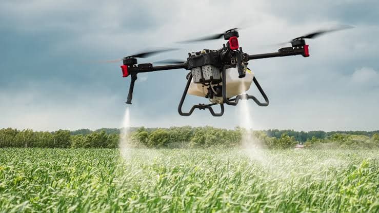 AgroSky agricultural spraying drone releasing a fine mist over a green crop field